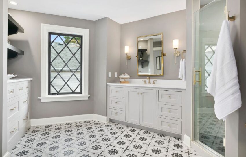 A bathroom featuring a sink and vanity unit with patterned floor tiles